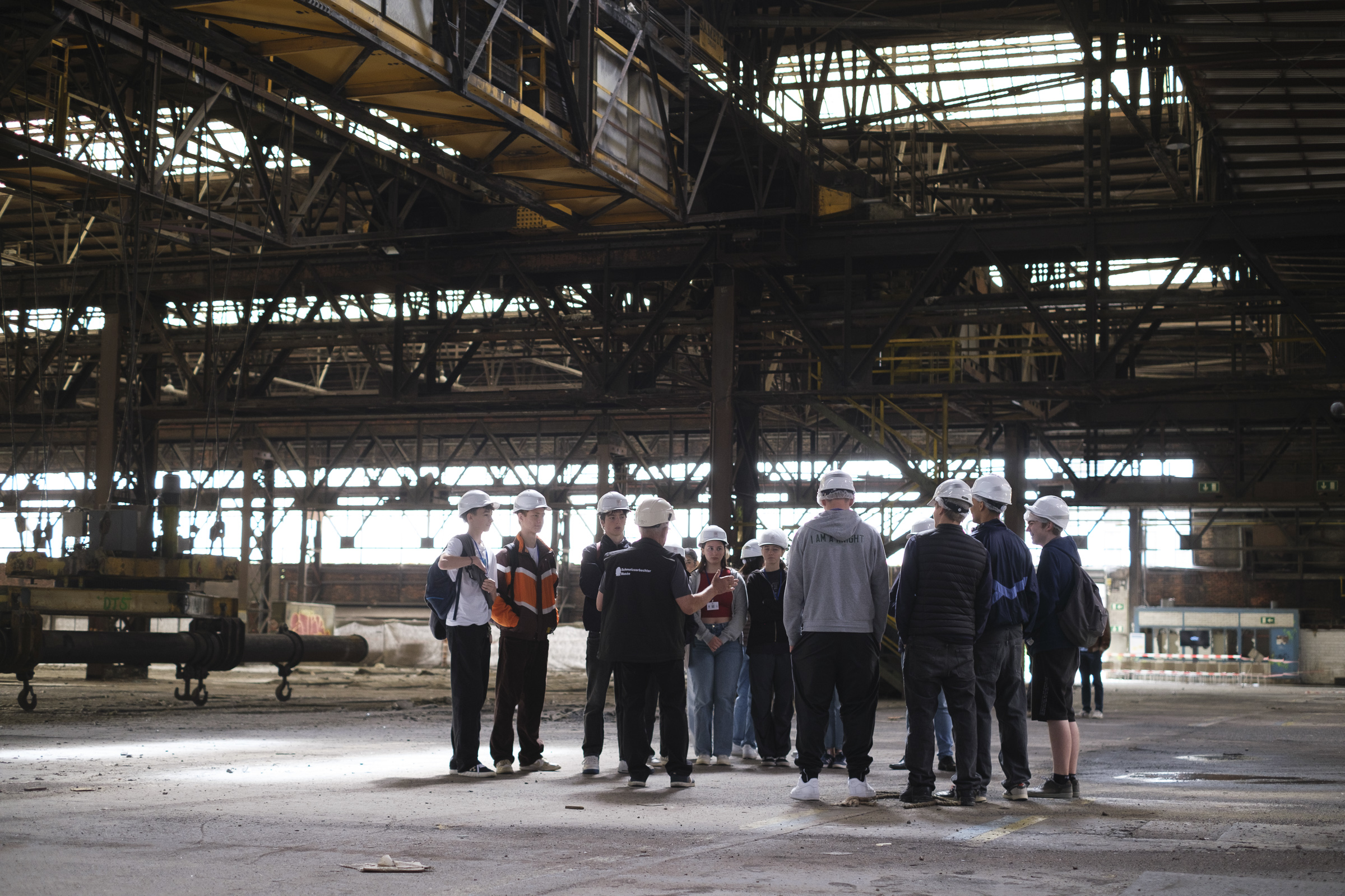 Eine Gruppe von Menschen steht in einer Industriehalle.