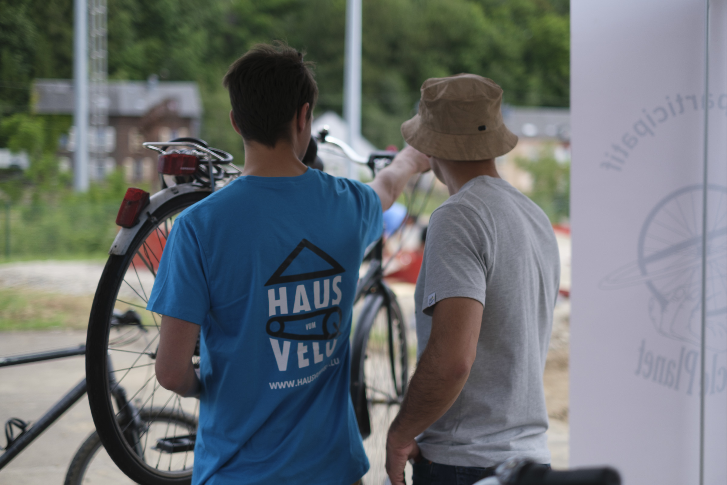 Zwei Menschen stehen vor einem umgedrehten Fahrrad.