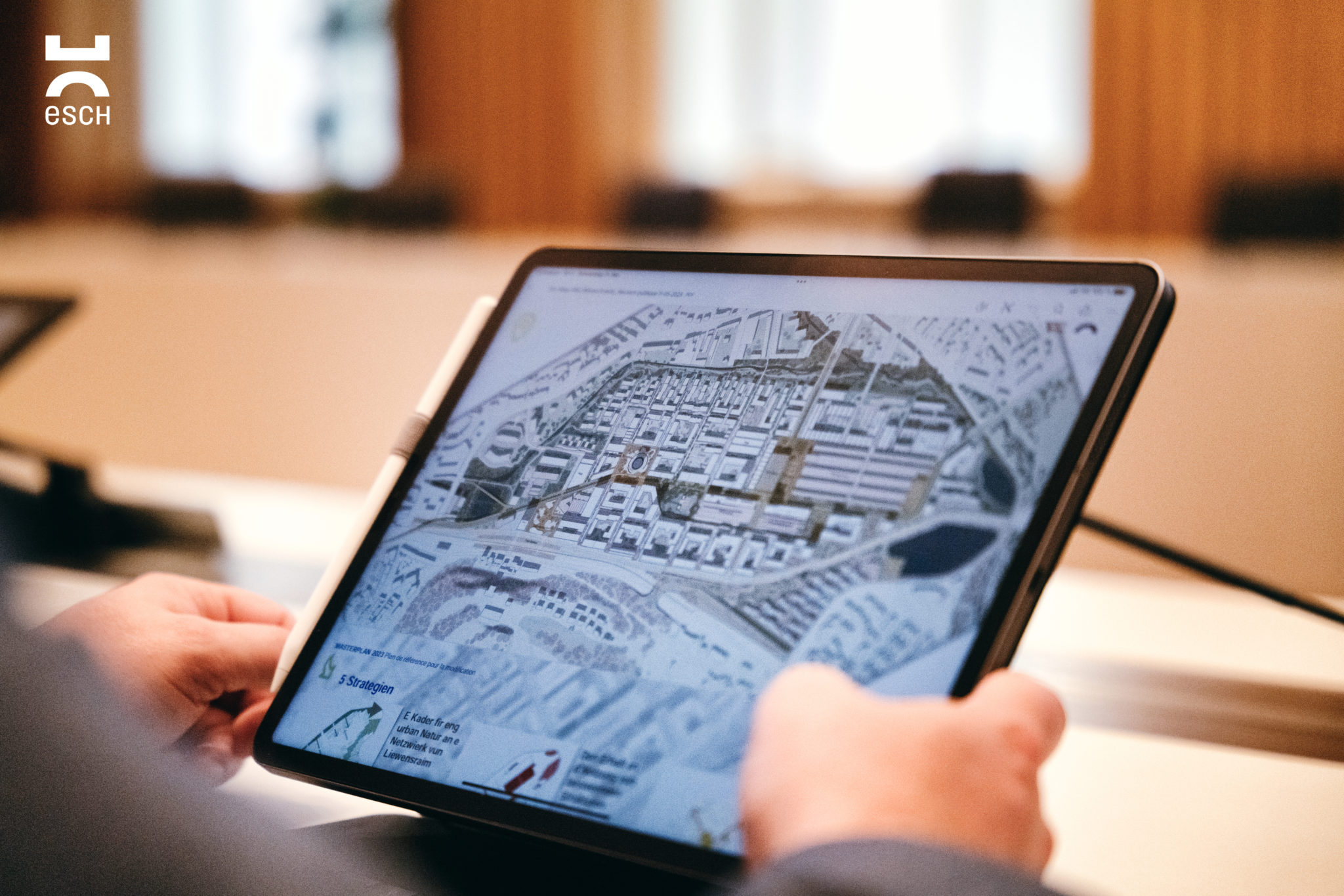 Hände halten Ipad auf dem ein Bebauuungsplan zu sehen ist (PAG)
